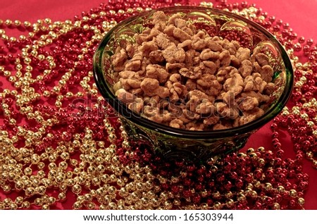 Healthy Holiday Snacking. Avoid the holiday weight gain; skip the candy and go nuts! A bowl of walnuts in a crystal bowl set on a festive holiday table.