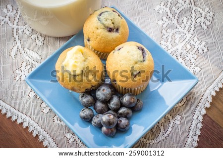 Blueberry Muffins. Fresh from the oven blueberry muffins with a slab of butter and a carafe of milk. A delicious start to the day.