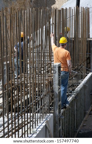 Construction workers between steel bars