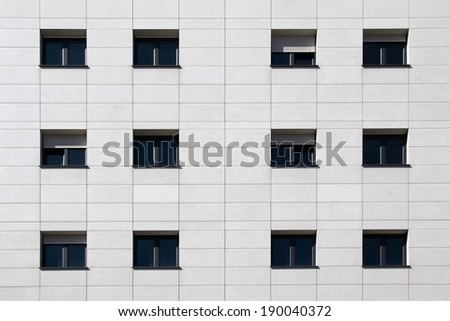 Black windows on white flagstone building facade