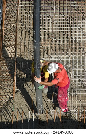 Two construction workers casting foundations of hydro power plant