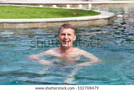 mature man swims in the pool hotel
