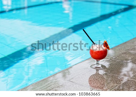 glass with drink costs on a pool side