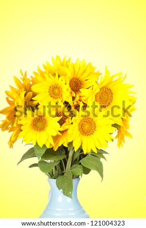 Big bouquet of sunflowers in a jug on a yellow background