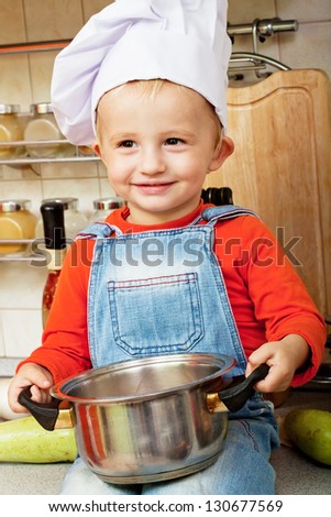 little boy on kitchen helps to make a dinner