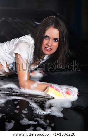 beautiful girl washes the car