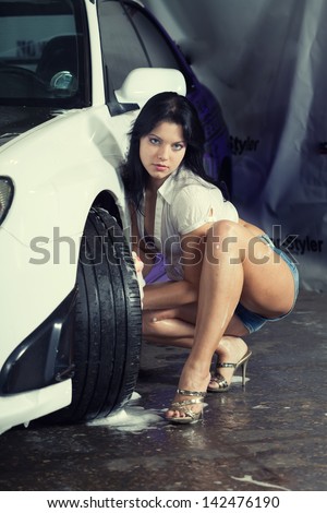 Beautiful girl washes the car