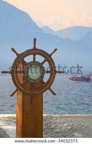  Fashioned Ship  Posters on Old Ship Steering Wheel Against The Sea And The Yacht Stock Photo