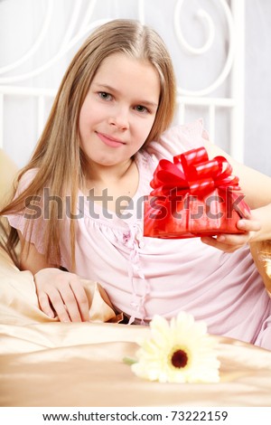 beautiful ten years\' girl has seen in bed a gift on birthday.