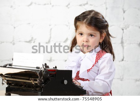three-year girl prints on the old typewriter