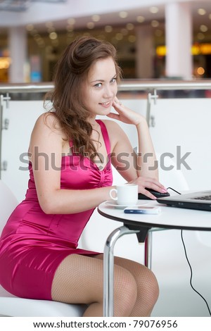 girl works on a laptop, sitting in cafe in shopping center