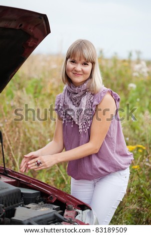 girl considers the engine at the broken car
