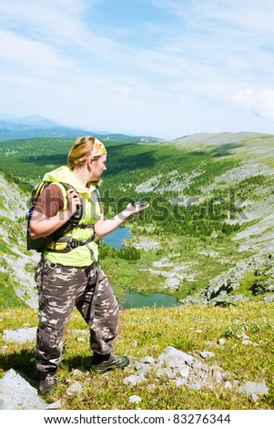 tourist in mountains with a compass in a hand