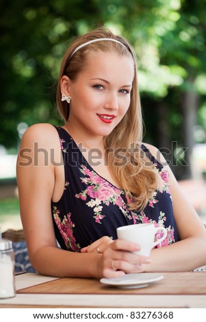 beautiful girl has a rest in street cafe in park