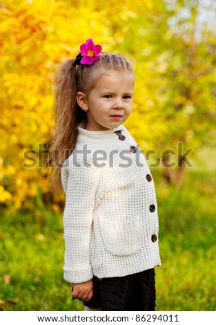 beautiful little girl on walk in autumn park