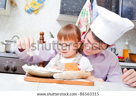 father with a small daughter do dough for pies