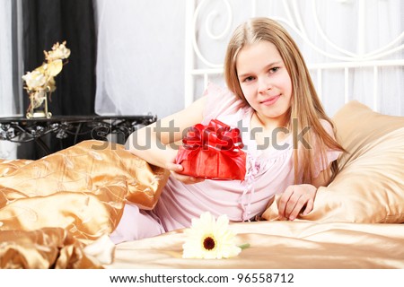 beautiful ten years' girl has seen in bed a gift on birthday.
