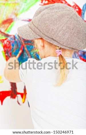 girl in a white T-shirt and a cap bedaubed with bright paints
