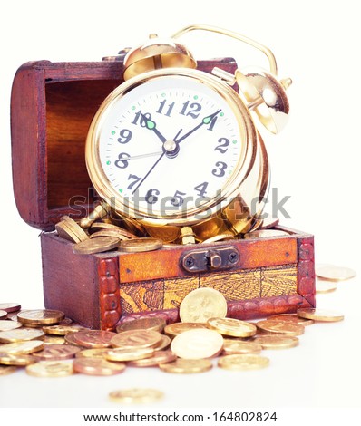 Gold alarm clock lay on money in a wooden chest