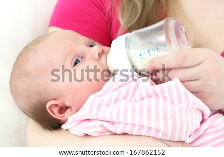 Feeding of  chest baby by a dairy mix from a children\'s small bottle