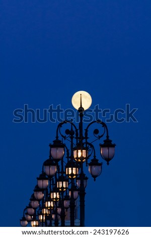 Big moon in a fullmoon against street lamps