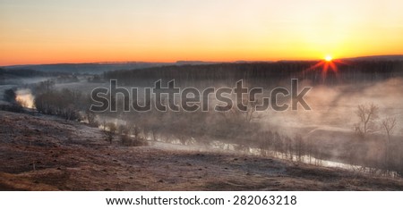 Sunrise through a river mist in the early spring