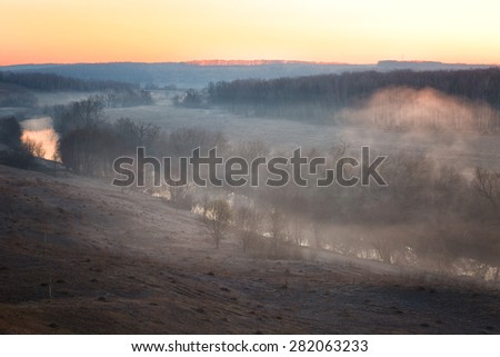 river mist lit with a rising sun, early spring