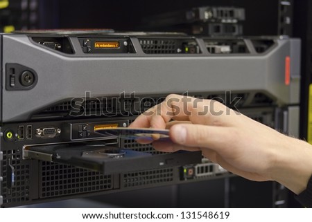 A technician install a 2 unit rack server in a data center.