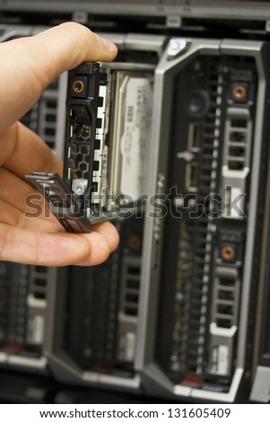 IT technician / consultant insert / remove a hard disk from a blade server data center. This is a 3,5\