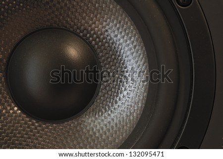Macro / close-up of a bass and mid-tone loudspeaker / studio monitor element in kevlar.