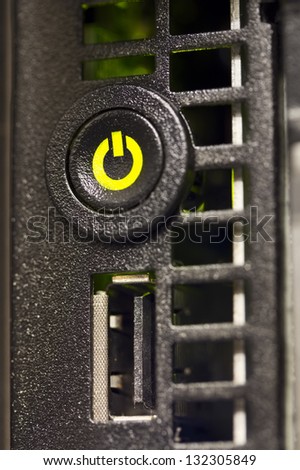 A close-up of a power on /power off button on a server in a rack. Shot in a data center.