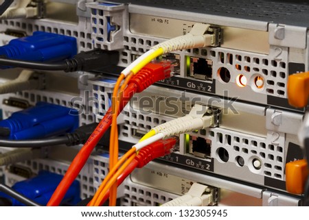 Close up of fiber and ethernet cards on rack servers. Shot in a datacenter.