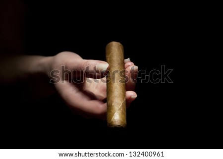 Woman holds a exclusive cuban cigar. Give away a cigar.