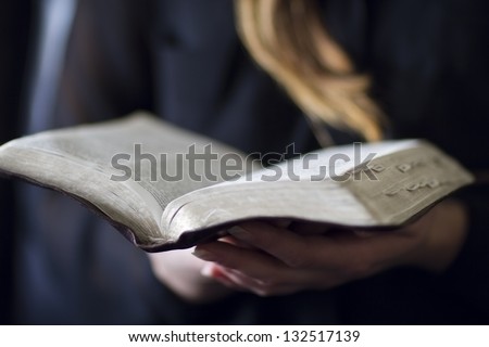 A close-up of a christian woman reading the bible. Very shallow depth of fields.