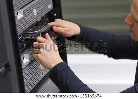 It engineer / consultant working in a data center. Install a new harddisk in a rack server.