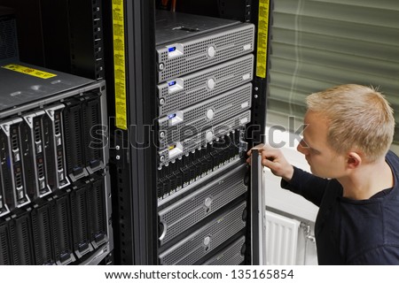 It engineer / consultant working in a data center. This enclosures is a SAN (storage area network) and servers at the top.