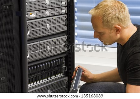 It engineer / consultant working in a data center. This enclosure is a SAN (storage area network) and servers at the top.