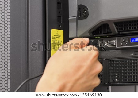 It engineer / consultant working in a data center. Plugs in a usb cable.