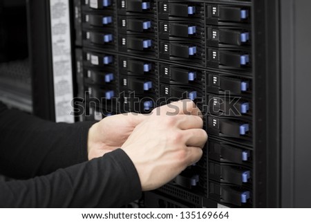 It engineer / technician working in a data center. Replace a hard drive in a SAN.