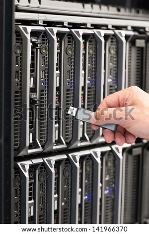 IT technician installs and maintain a blade servers in a data center. Plugs in a flash drive.