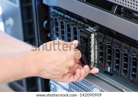 It engineer / technician working in a data center. Disk cabinet and servers.