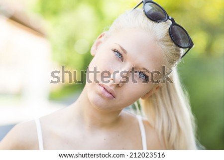 Good looking blonde teen girl face in the sun