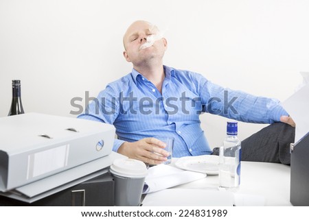 Businessman smokes and drinks at the office