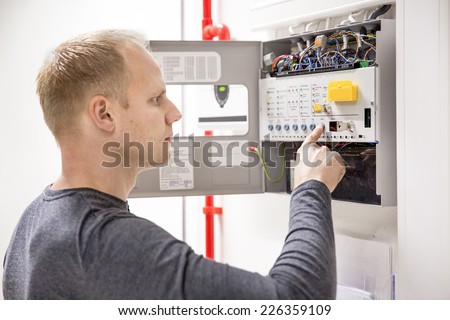 Technician checks fire panel in data center