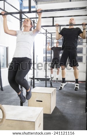 Workout team trains pullups at fitness gym