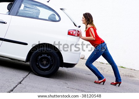 woman pushing car out of gasoline