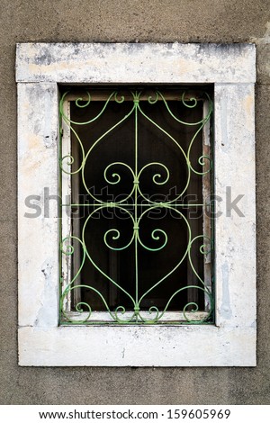 Rusty green metal window with decorative bars