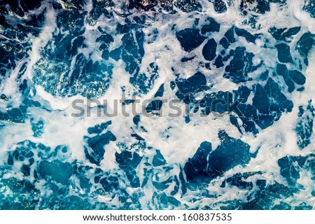 Areal shot of deep blue and rough sea with lot of sea spray