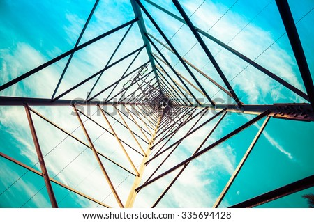 Silhouette shot of electricity pylons with cloudy sky