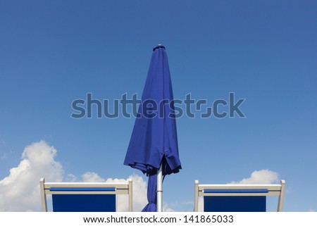 Deck chairs sun umbrella  and blue sky